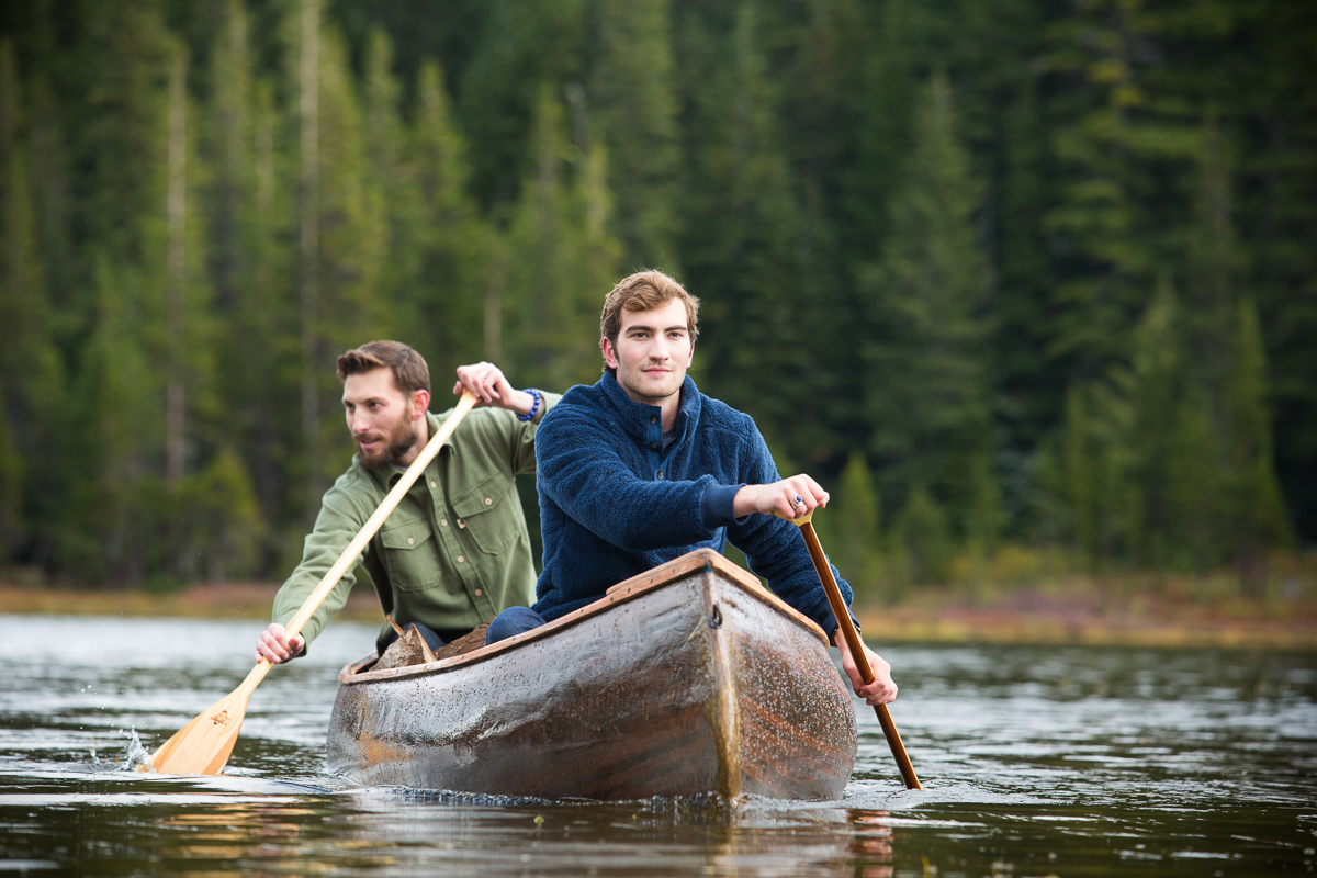 Two young men paddling a canoe on Oregon lake